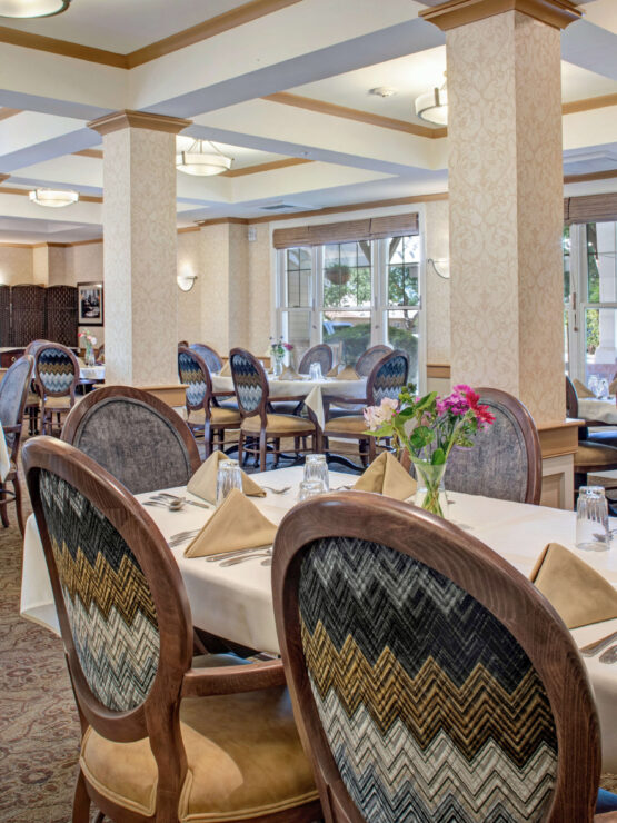 Bright, inviting dining room with elegant seating and fresh flowers, fostering community and comfort.