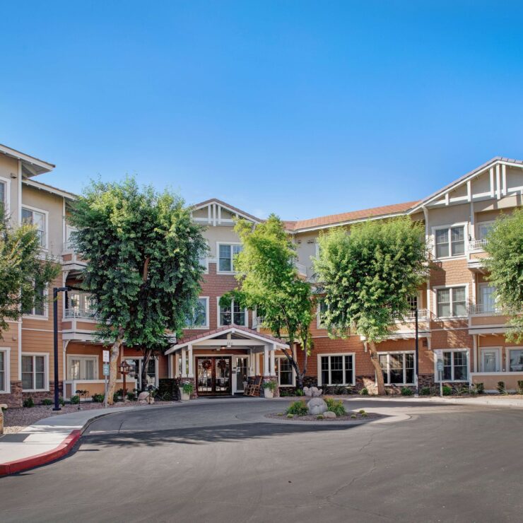 Welcoming retirement community with shaded walkways and comfortable outdoor seating areas.