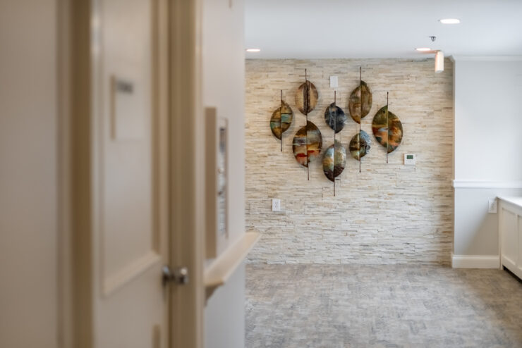 Welcoming hallway with artistic wall decor and soft lighting, creating a peaceful community space.