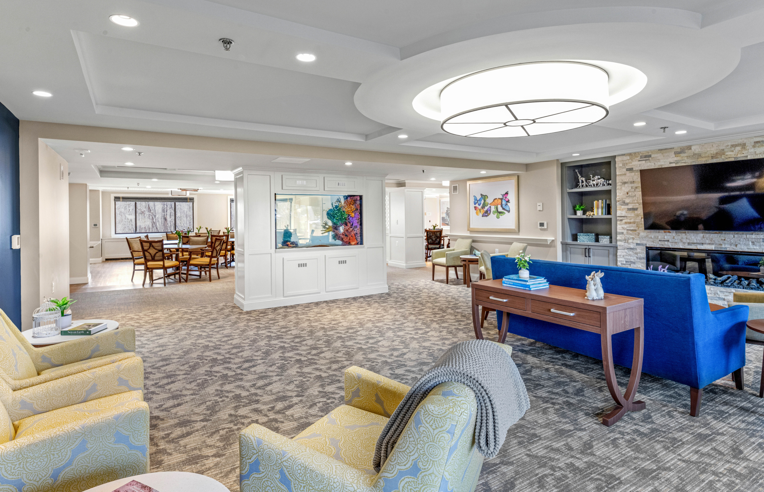 Bright, inviting communal lounge with comfortable seating, large aquarium, and dining area for socializing.