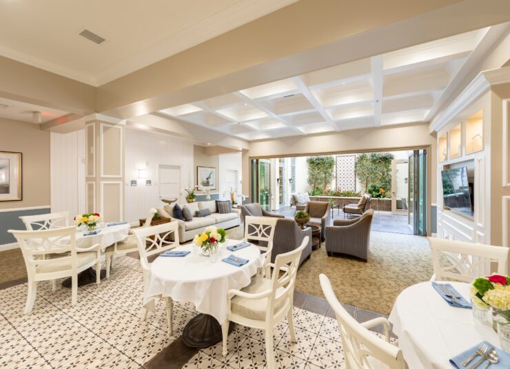 Bright and inviting lounge with comfortable seating and open access to a peaceful garden courtyard.