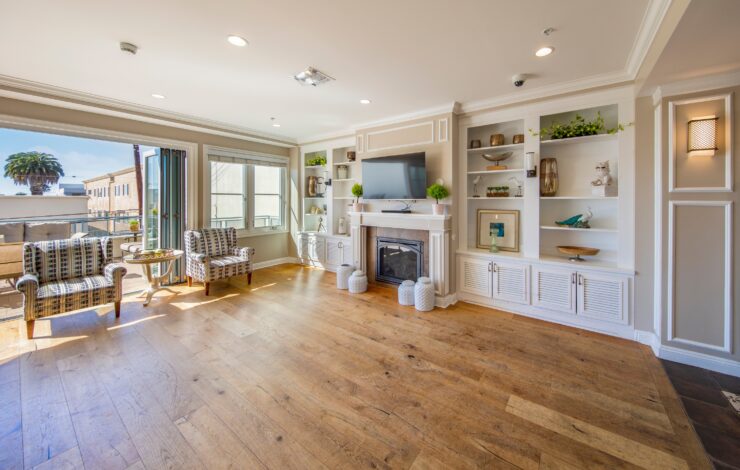 Sunny lounge area with comfortable seating, fireplace, and open access to a patio space.