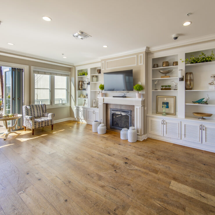 Sunny lounge area with comfortable seating, fireplace, and open access to a patio space.