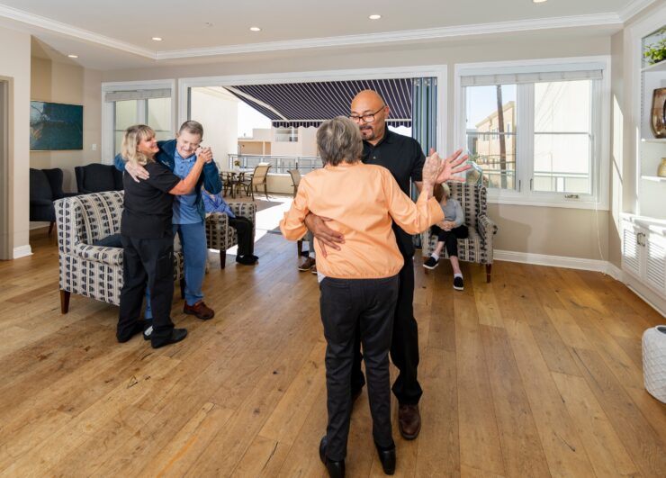 Residents enjoy dancing and socializing in a bright, welcoming common room with outdoor access.