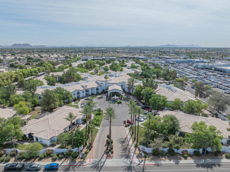 Retirement community surrounded by greenery with mountain views and welcoming pathways.