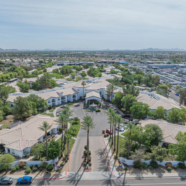 Retirement community surrounded by greenery with mountain views and welcoming pathways.