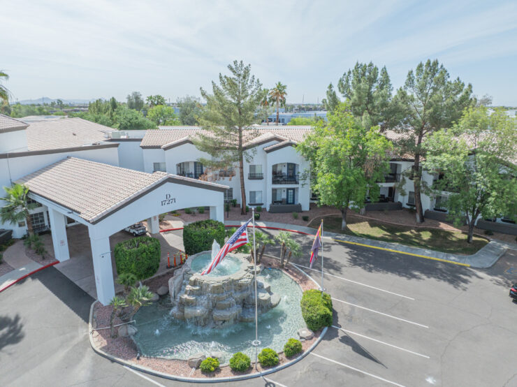 Retirement community with welcoming entrance, peaceful greenery, and a central water fountain.
