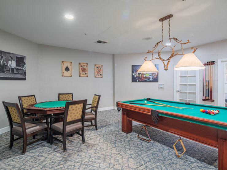 Recreation room with pool table and card table, warm lighting, and inviting decor for socializing.