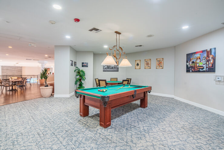 Well-lit game room with a pool table and seating area, perfect for socializing and relaxation.