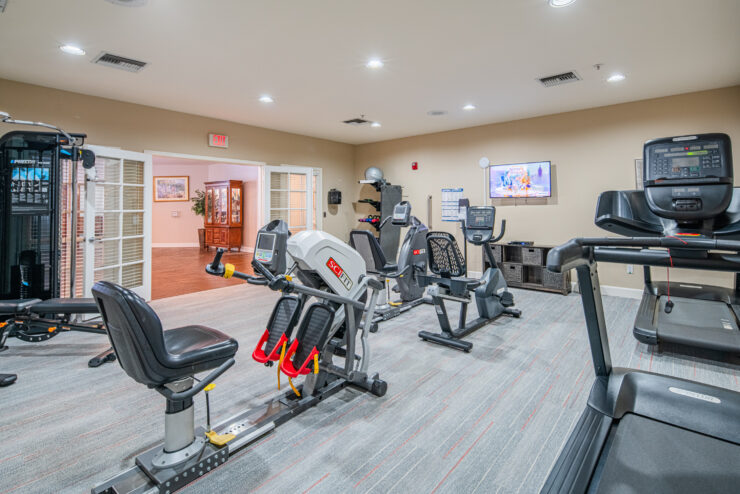Bright, well-equipped fitness room with exercise machines and a welcoming atmosphere for seniors.