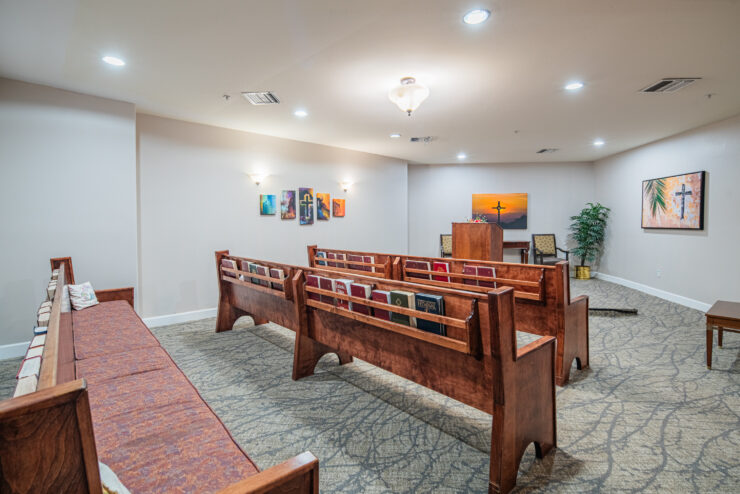 Small chapel with wooden pews, uplifting artwork, and a peaceful, welcoming atmosphere.