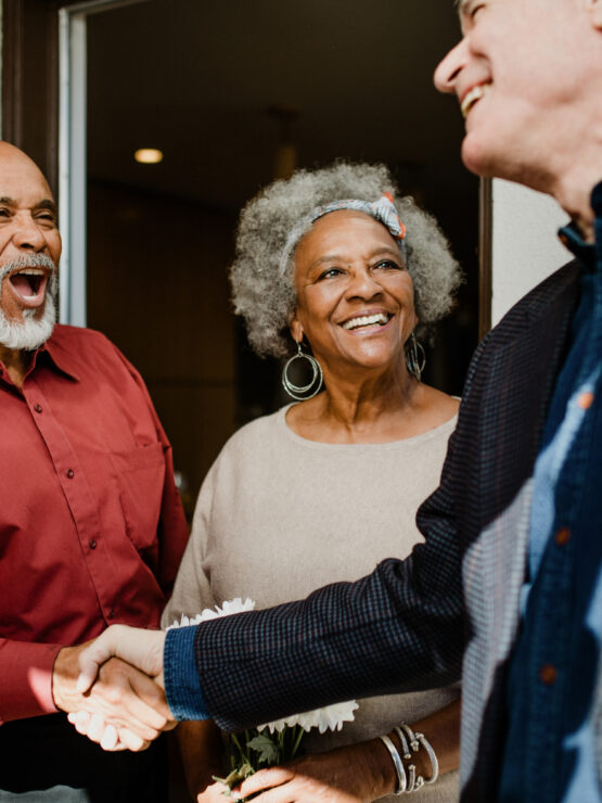Seniors warmly greeting and chatting together, highlighting a friendly and welcoming community.