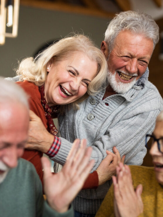 Seniors sharing joyful moments and laughter in a warm, inviting community space.