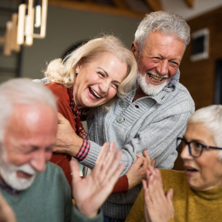 Seniors sharing joyful moments and laughter in a warm, inviting community space.