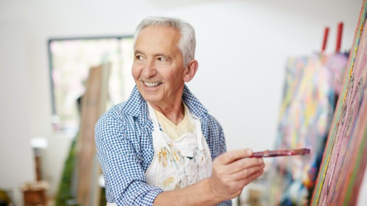 Senior man enjoying painting in a bright, welcoming art studio at a retirement community.