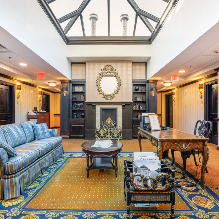 Sunlit seating area with fireplace, antique furnishings, and inviting decor for residents' relaxation.