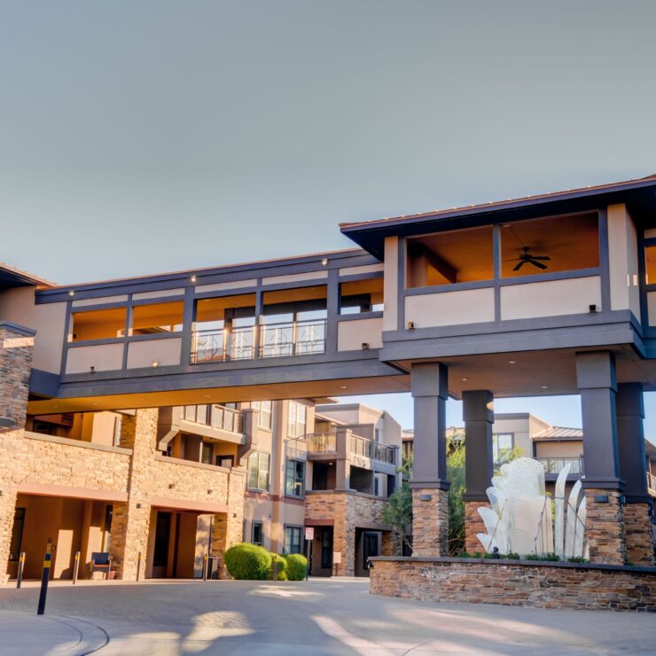 Modern retirement community with inviting walkways, spacious balconies, and warm natural materials.
