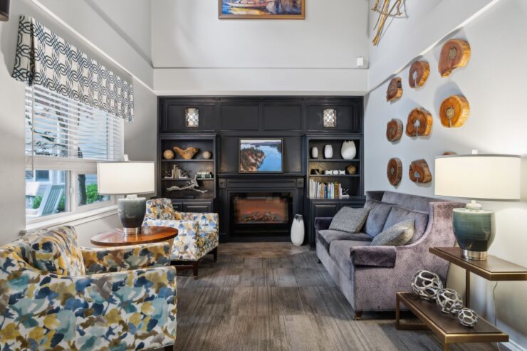 Warm living room with comfortable seating, a fireplace, and natural wood wall art fostering community.