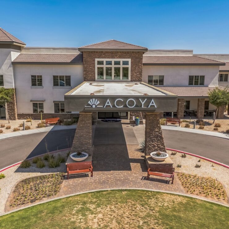 Modern retirement community with spacious entry, landscaped grounds, and inviting outdoor seating.