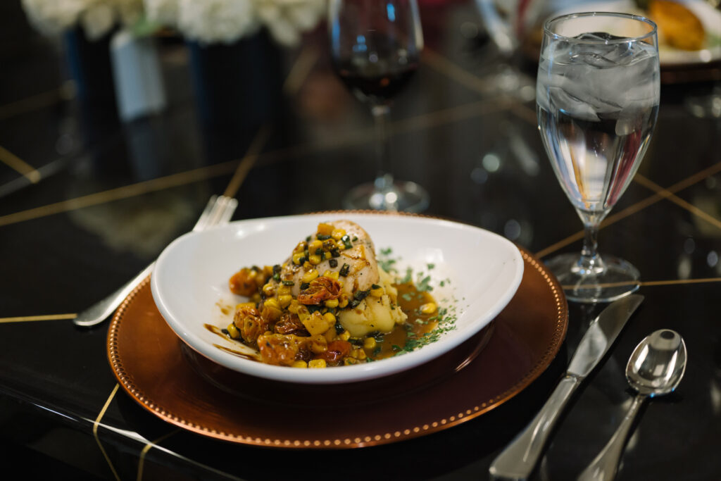 Elegant dining setup with flavorful meal and refreshing drink on a polished table.