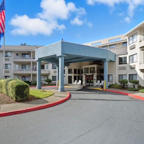 Well-maintained retirement community entrance with seating, landscaping, and a welcoming atmosphere.