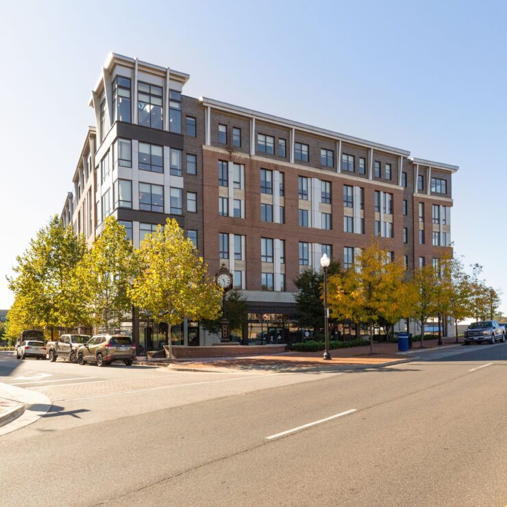 Modern building surrounded by trees and parked cars, offering a welcoming community atmosphere.