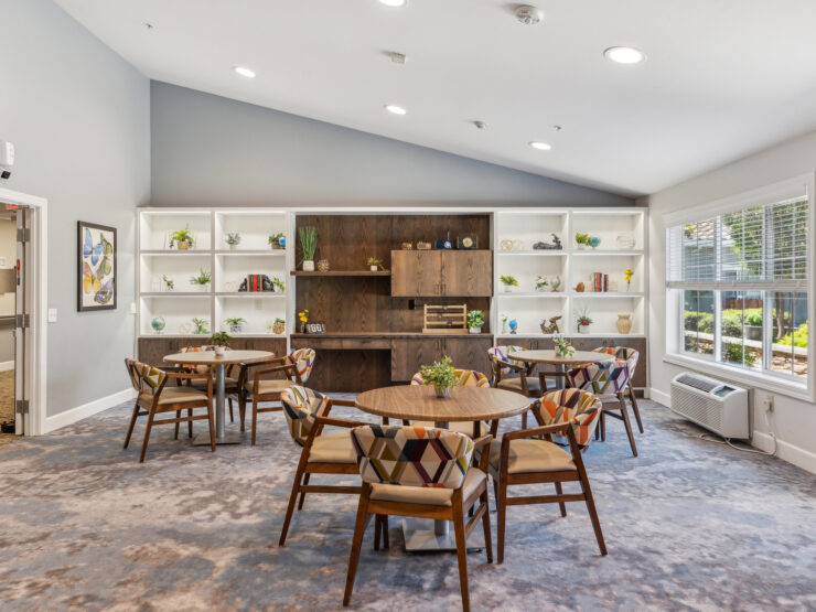 Bright dining area with round tables, patterned chairs, and cheerful decor fostering community gatherings.