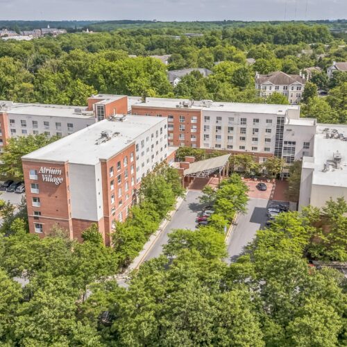 Retirement community surrounded by lush trees, offering a peaceful and welcoming environment.