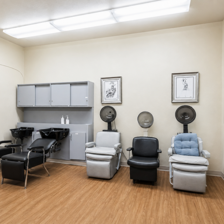 Salon area with comfortable chairs and hair-washing stations fostering social well-being.