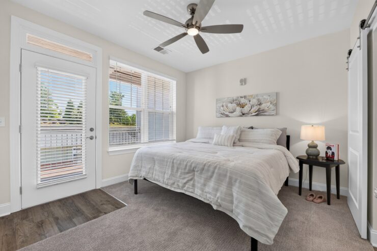 Bright, inviting bedroom with large windows, a comfortable king bed, and tranquil decor.