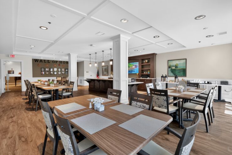 Bright dining area with comfortable seating, warm wood tones, and a welcoming wall of honor.
