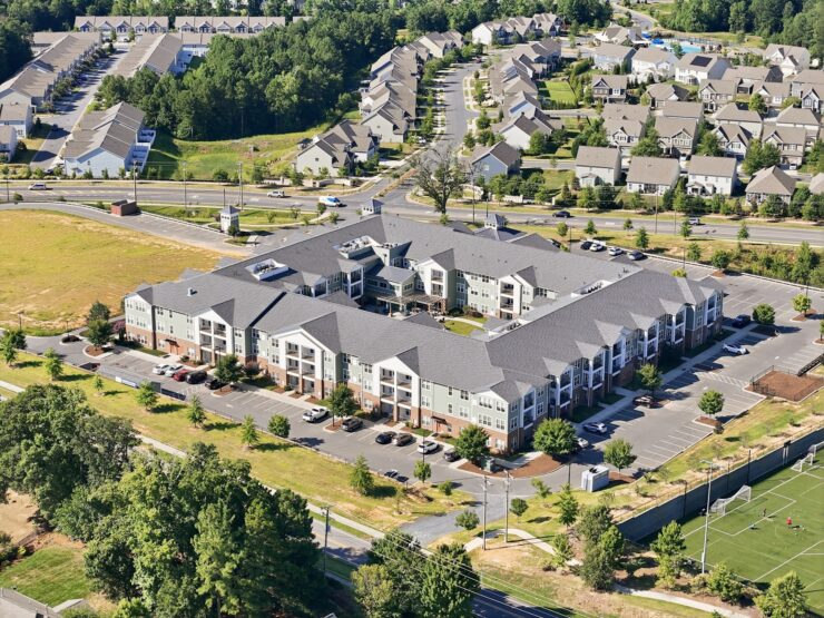 Spacious retirement community surrounded by greenery with ample parking and nearby walking paths.