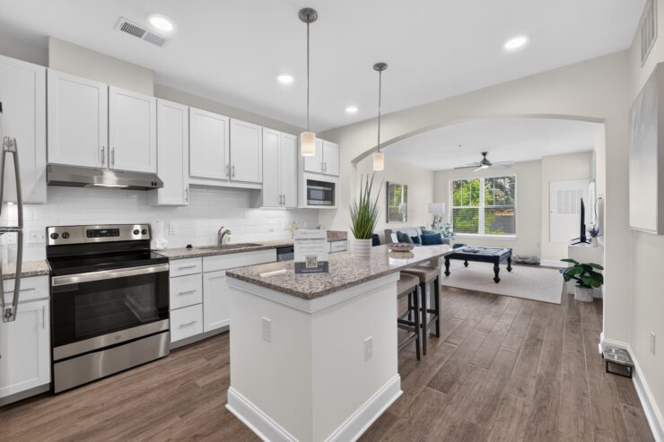 Bright kitchen and living area with a spacious island, seating, and natural light for community gatherings.