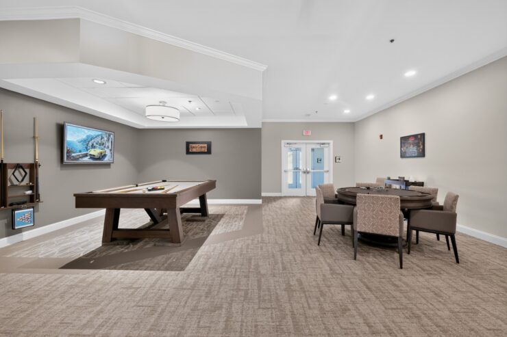 Inviting game room with pool table and card table fostering social connection and relaxation.