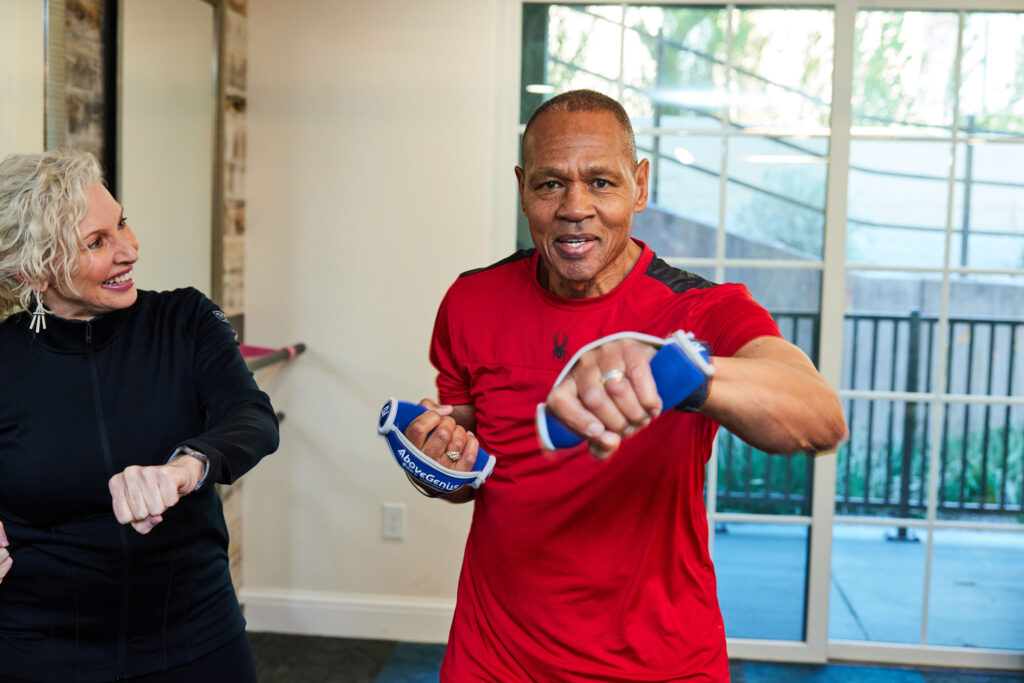 Two seniors engaging in a lively fitness session, fostering health and connection together.