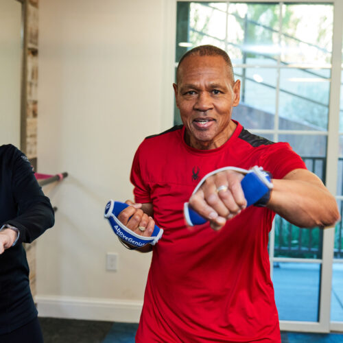 Two seniors engaging in a lively fitness session, fostering health and connection together.