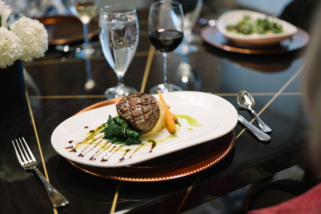 Elegant dining setting with gourmet meal, fresh wine, and inviting ambiance for guests.