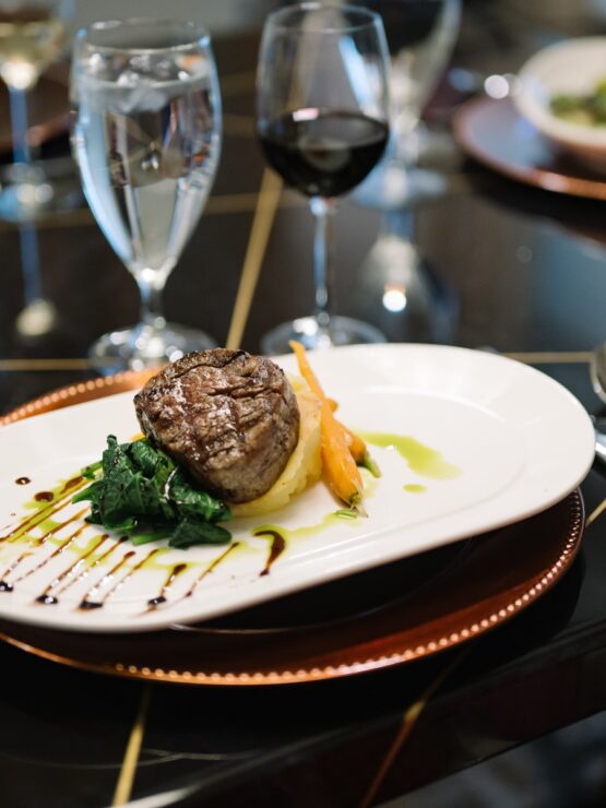 Elegant dining setting with gourmet meal, fresh wine, and inviting ambiance for guests.
