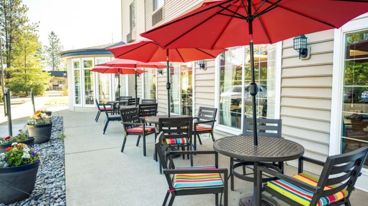 Outdoor seating area with shaded tables and colorful cushions inviting social gatherings.