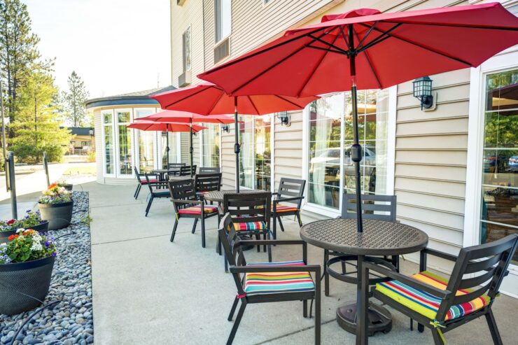 Outdoor seating area with shaded tables and colorful cushions inviting social gatherings.