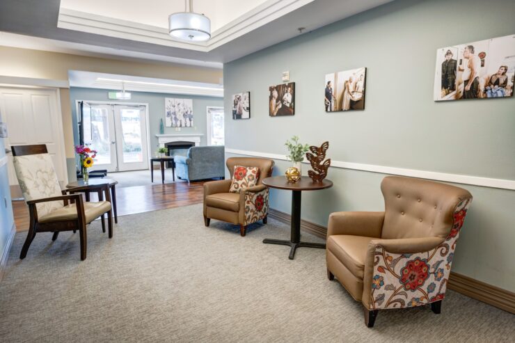 Comfortable seating area with armchairs, artwork, and natural light in a welcoming community space.
