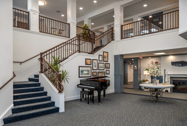 Welcoming retirement home lobby with grand piano, comfortable seating, and elegant décor.