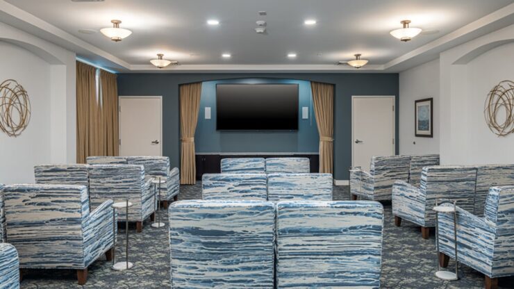 Spacious community room with comfortable seating and large TV for group activities and entertainment.