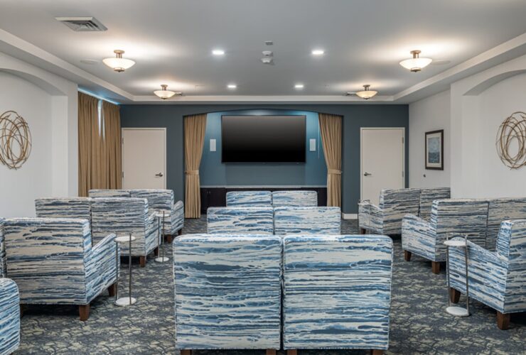 Spacious community room with comfortable seating and large TV for group activities and entertainment.