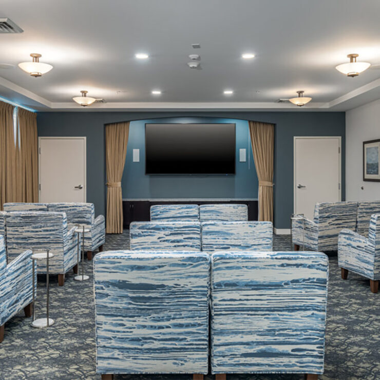 Spacious community room with comfortable seating and large TV for group activities and entertainment.