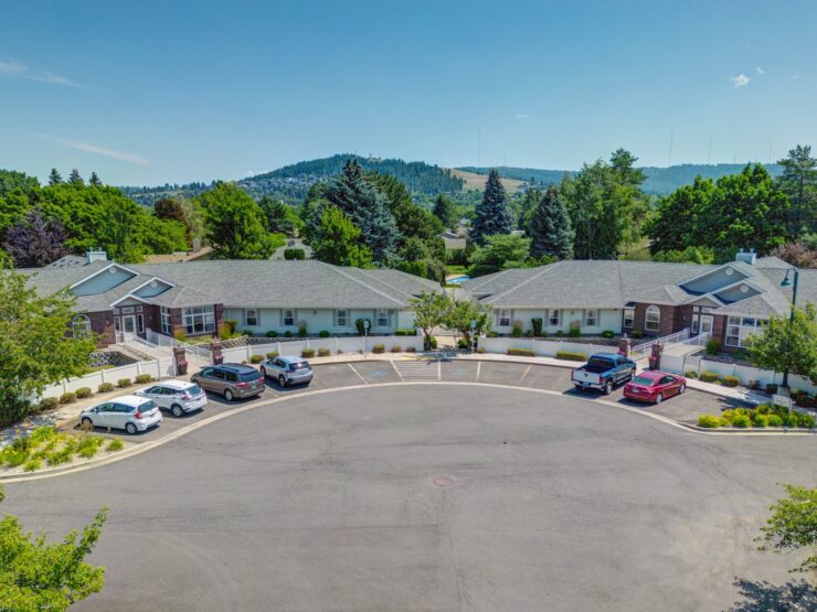 Retirement community with accessible pathways, welcoming entrances, and scenic tree-lined surroundings.
