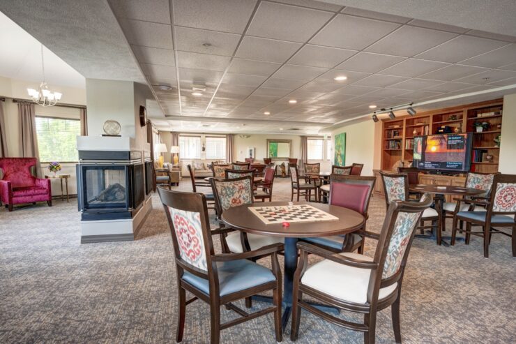 Bright and welcoming game room with seating, fireplace, and entertainment for community gatherings.