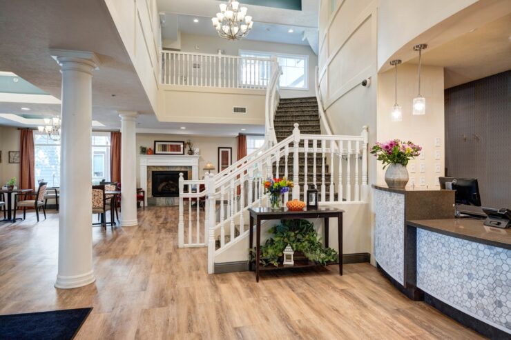 Welcoming retirement home lobby with bright seating areas, fireplace, and fresh floral accents.