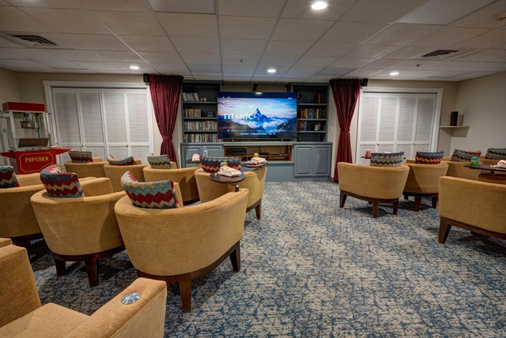 Comfortable theater room with plush seating, a large screen, and a popcorn machine for shared enjoyment.