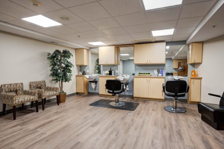Bright salon area with comfortable seating and welcoming styling stations for residents.